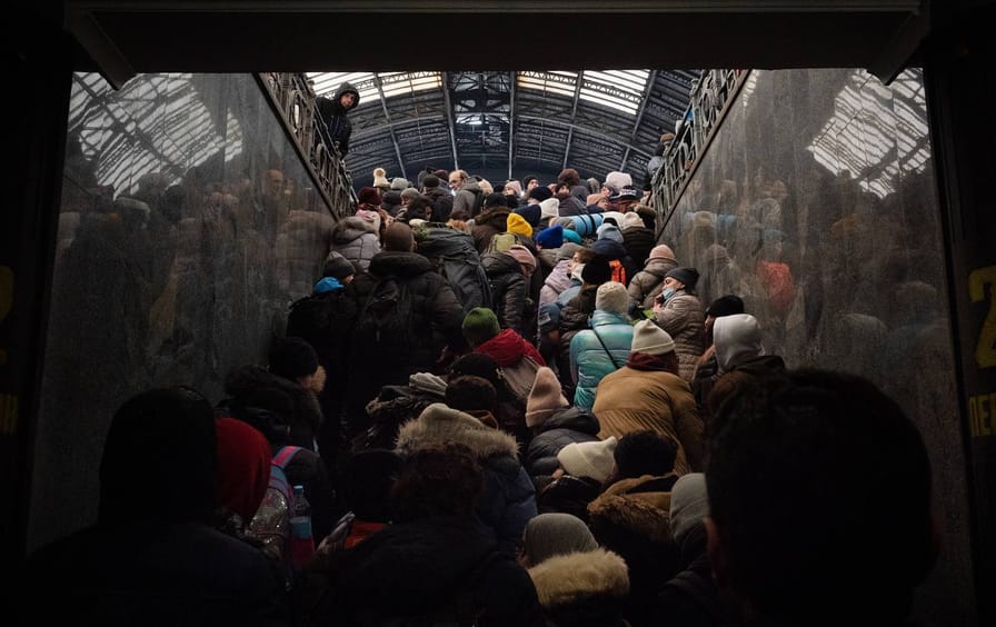A crowd of people in winter coats climbs a staircase