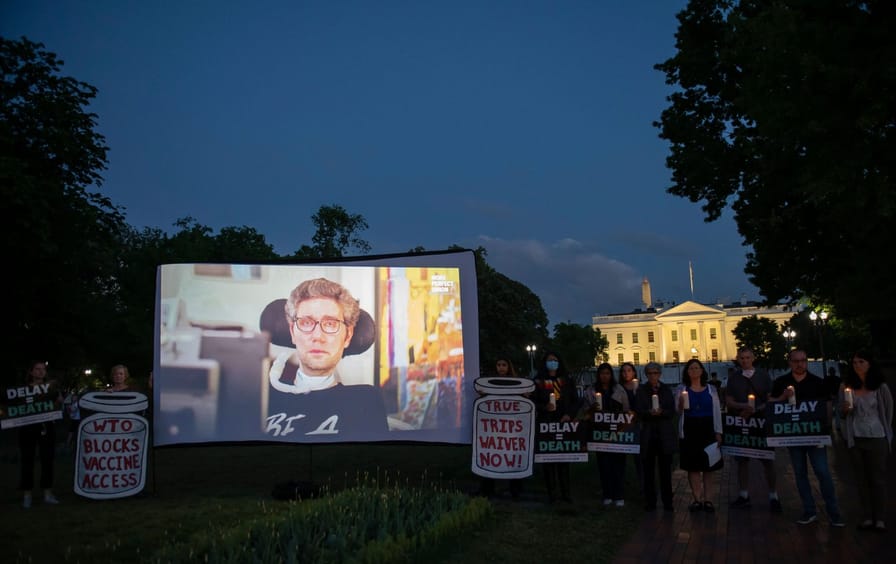 A protest with a screen showing Ady Barkan outside the White House