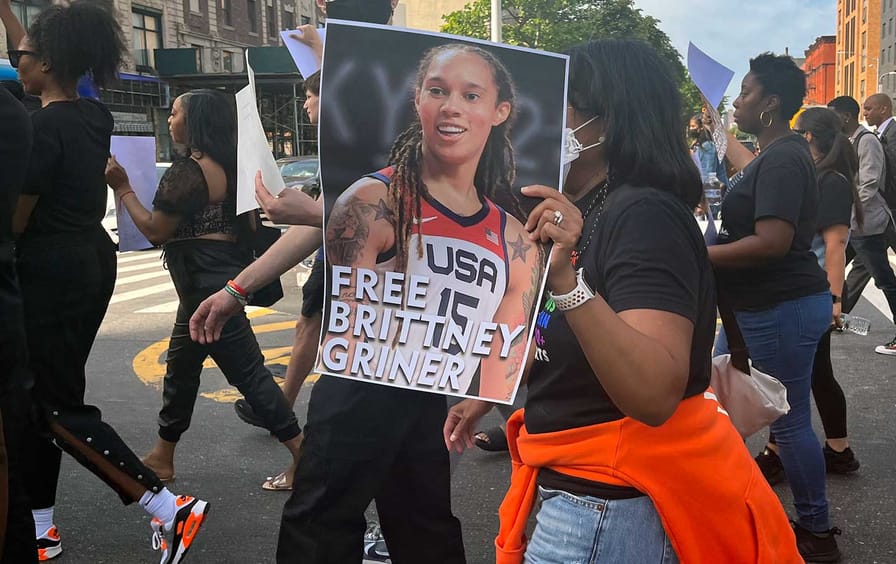 A protester holds up a poster of Brittney Griner, which reads Free Brittney Griner.
