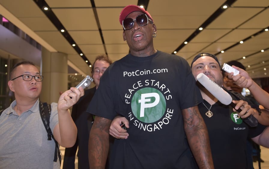 Retired professional basketball player Dennis Rodman speaks to the press as he arrives at Changi International airport ahead of US-North Korea summit in Singapore