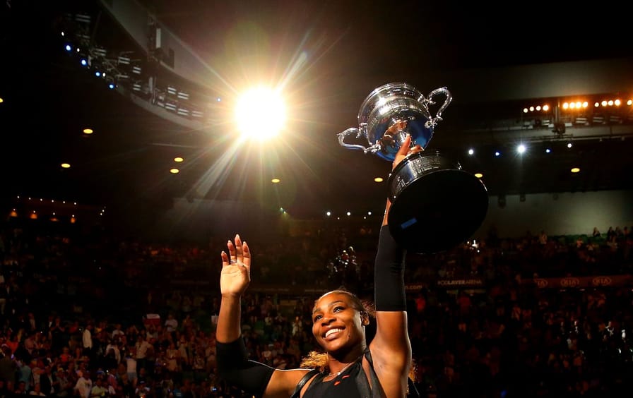 Serena Williams carries a trophy and waves to the crowd after winning the Women's Singles Final at the 2017 Australian Open.