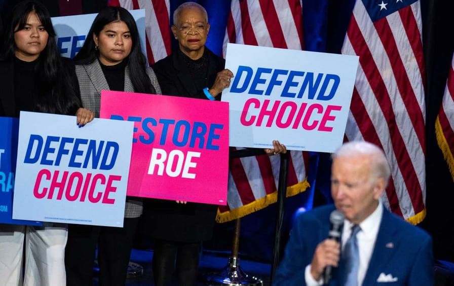 Activists stand in the background as Joe Biden delivers a speech