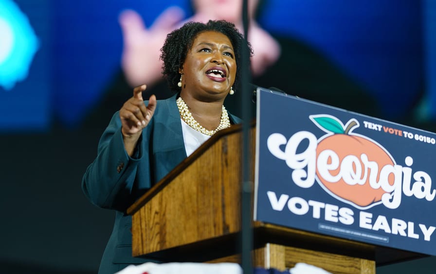 Stacey Abrams at a podium at a voter rally
