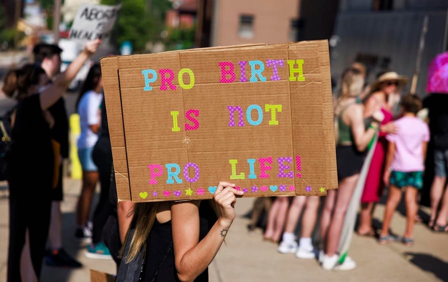 An abortion-rights demonstrator holds a placard reading,