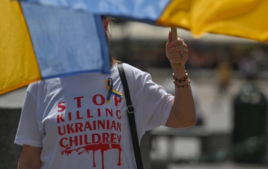 Ukrainian protester with face obscured by flag
