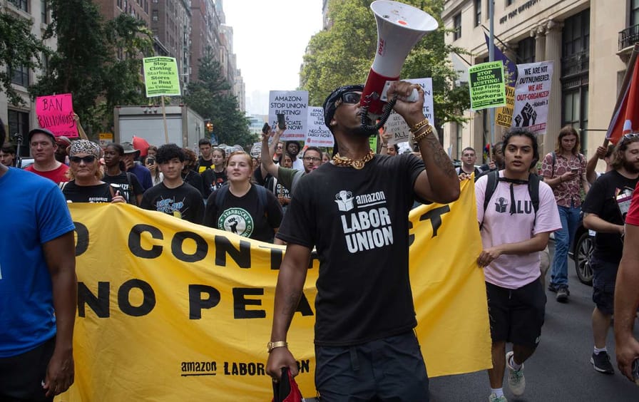 Chris Smalls holds a megaphone leading Starbucks and Amazon labor day protest