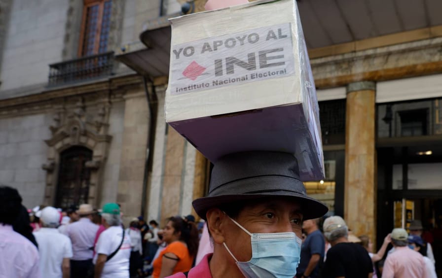 People carry representations of ballot boxes on their heads during a march in Mexico City on March 21st, 2021. The demonstration was held to protest the proposed Electoral Reform presented by President Andres Manuel Lopez Obrador.