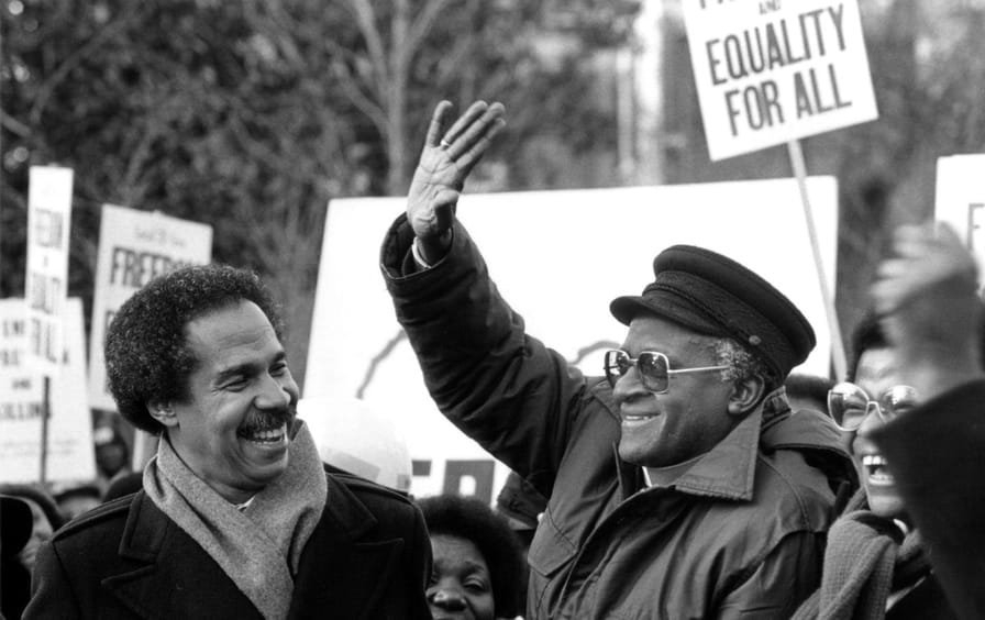 Randall Robinson, uitvoerend directeur van TransAfrica (links) met aartsbisschop Desmond Tutu tijdens een protest bij de Zuid-Afrikaanse ambassade in 1984
