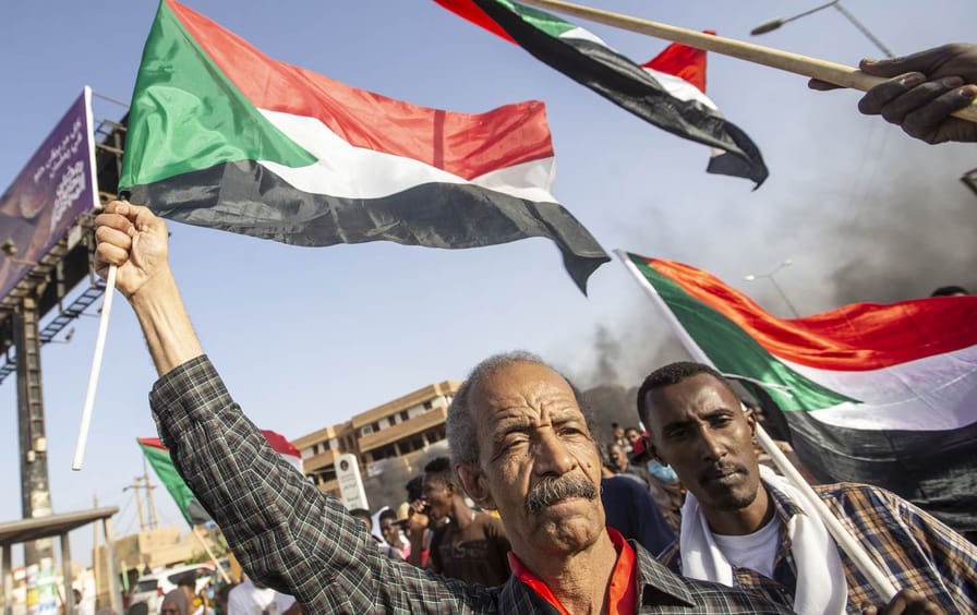 men hold flags in Karthoum