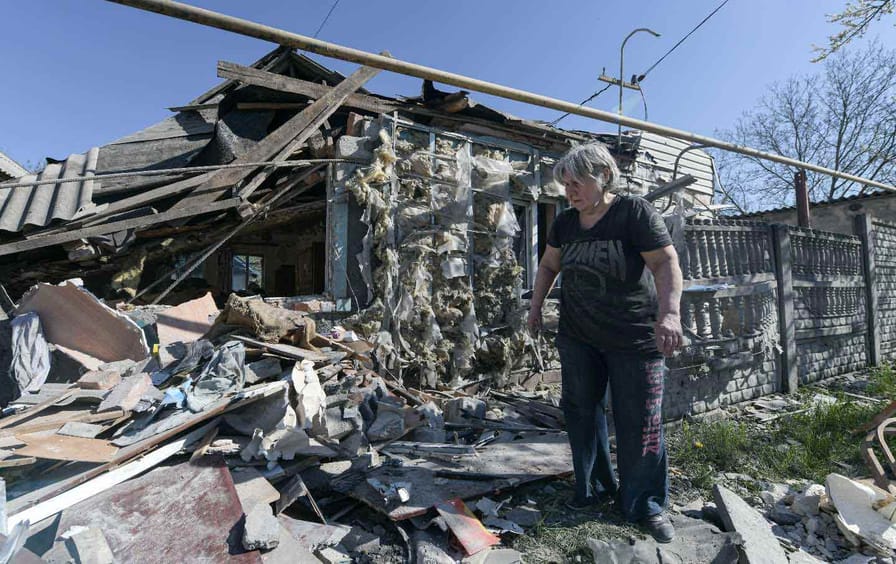 A woman goes through the rubble of her ruined house after the shelling in Russian-controlled territory of Donetsk, Ukraine.