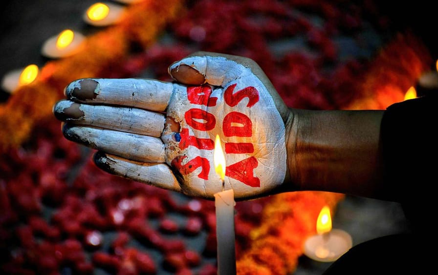 An activist in Kolkata, India, paints her palm with the “Stop AIDS” message to mark World AIDS Day on December 1, 2022.
