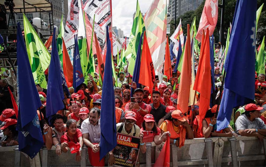 people hold flags at a may day rally in Brazil
