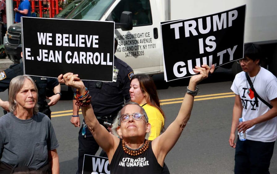 Protesters wave signs outside the Southern District of New York Court during the E. Jean Carroll trial.