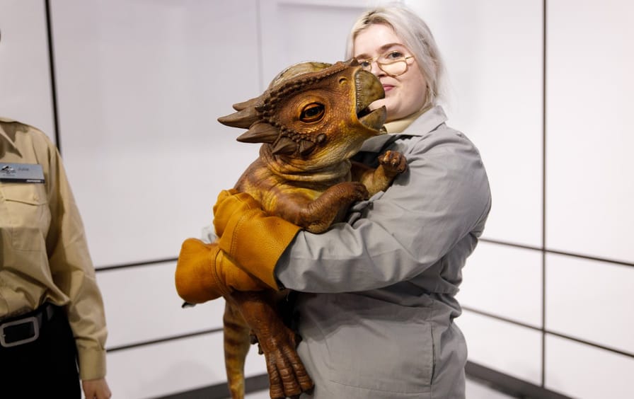 Museum guard holds robot dinosaur