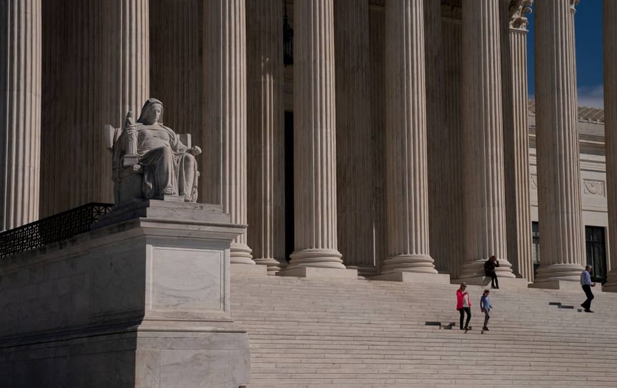 Visitors walk down the steps of the US Supreme Court Building in Washington, D.C.