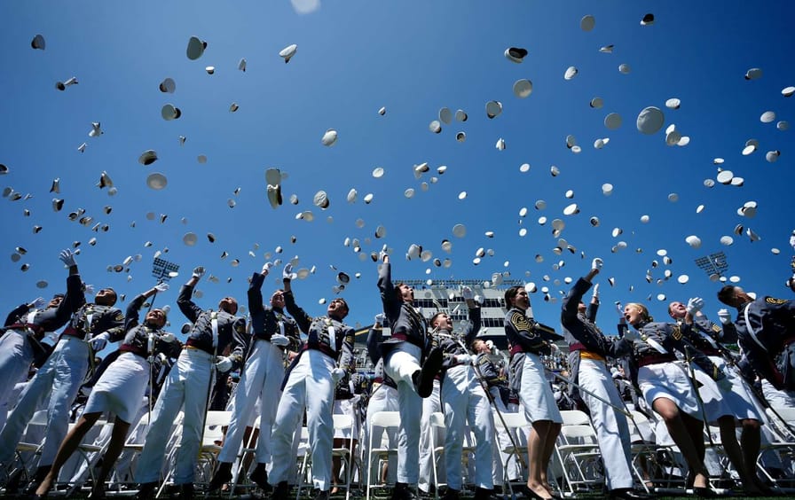 West Point graduates throw their caps