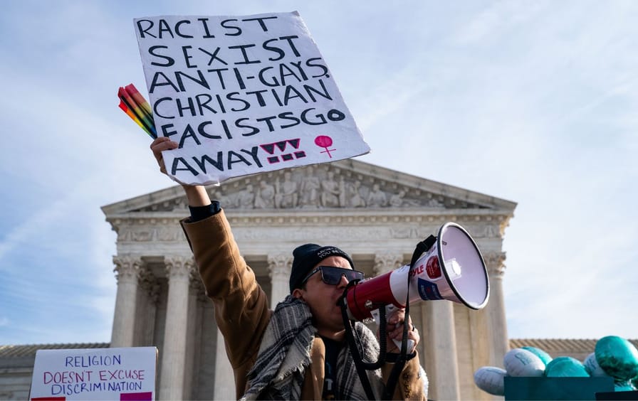 A protester outside the Supreme Court holding a sign reading 