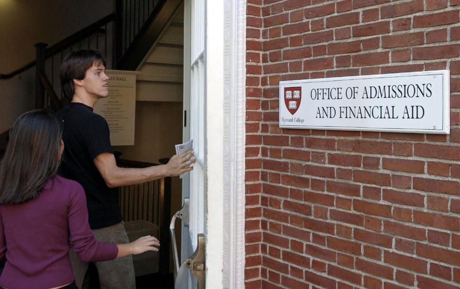 Students enter the Admissions Building on the campus of Harvard University n Cambridge, Massachusetts.