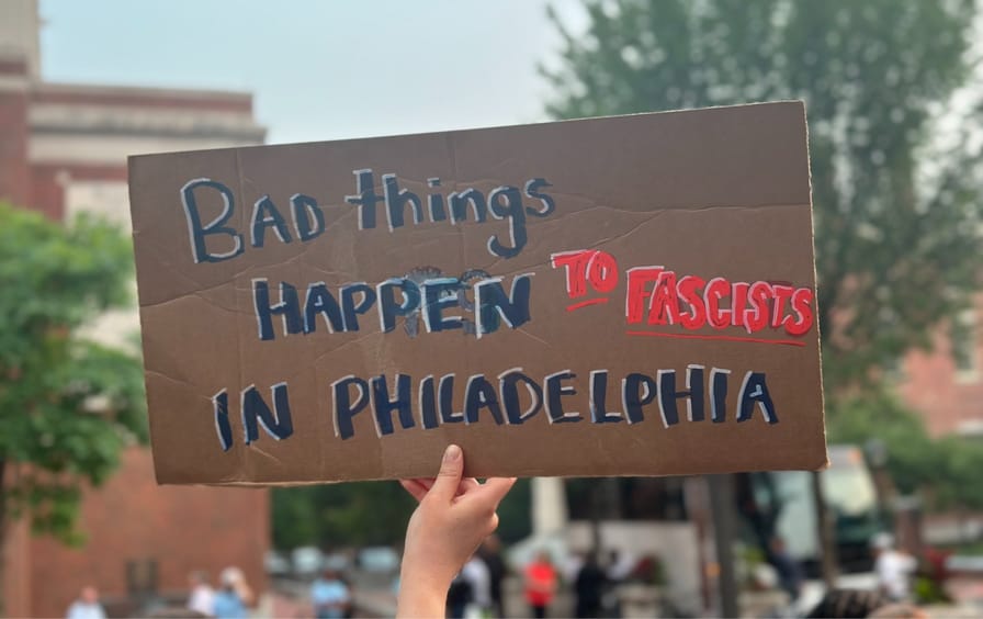 A protester holds a sign reading, “BAD THINGS HAPPEN TO FASCISTS IN PHILADELPHIA.”