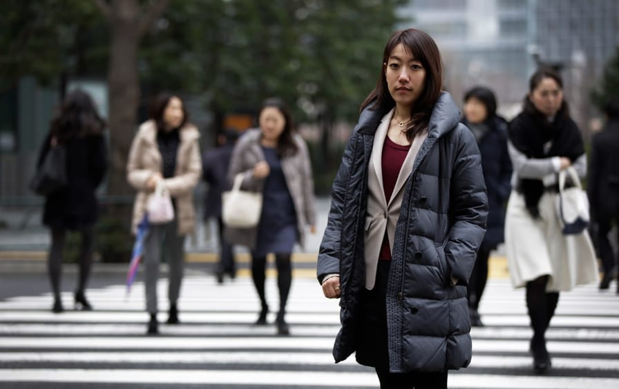 Japanese woman standing at a crosswalk
