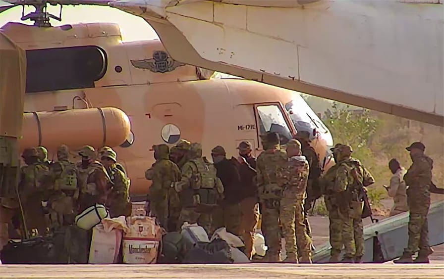 Wagner group mercenaries board a helicopter.