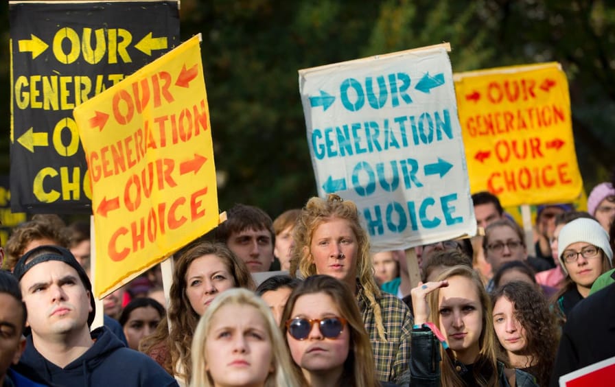 young people hold colorful posters that read: our generation our choice