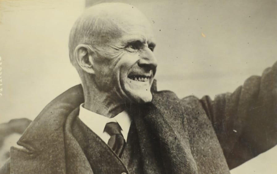 Black-and-white photo of Eugene Debs waving to s crowd in 1921