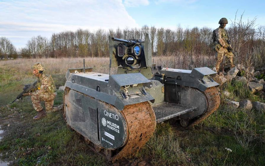 soldiers surround unmanned robotic ground weapon in field