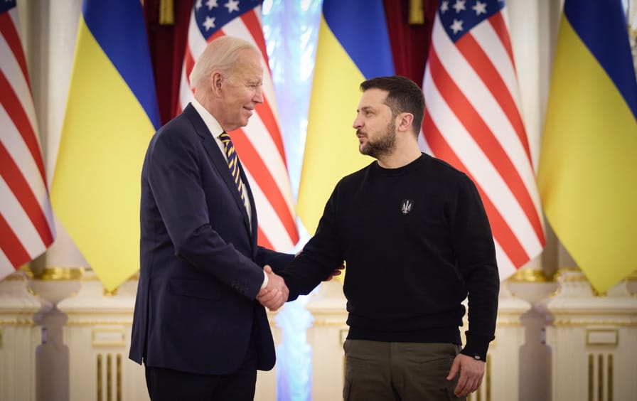 photo of biden and zelenskyy with us and ukrainian flags in the background