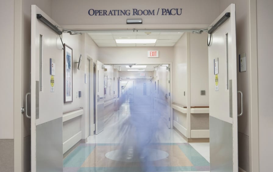 A blurred motion shot in a hospital corridor.