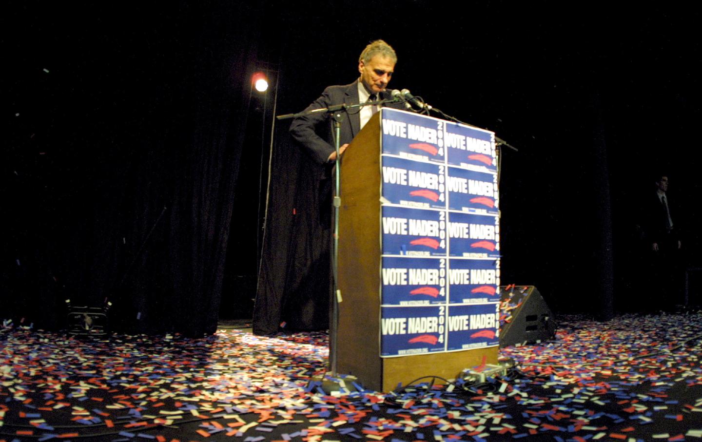 Ralph Nader stands onstage at a campaign event in 2004