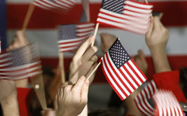 Numerous white hands holding the American flag, with the American flag as a background