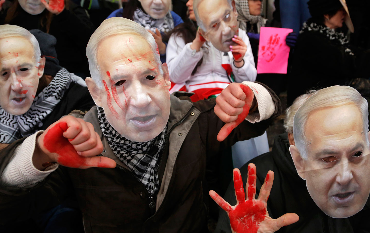 Demonstrators led by the protest group Code Pink wear masks of Israeli Prime Minister Benjamin Netanyahu as they sit at the entrance to the AIPAC policy conference, March 1, 2015.