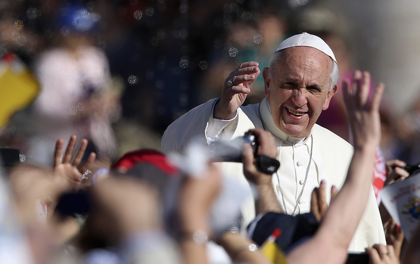 Pope Francis waves as he arrives to lead his Wednesday general audience in Saint Peter's square at the Vatican.