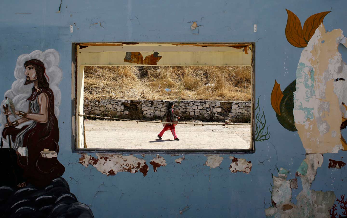 A girl walks at a refugee and migrant camp on the northeastern Greek island of Lesvos.