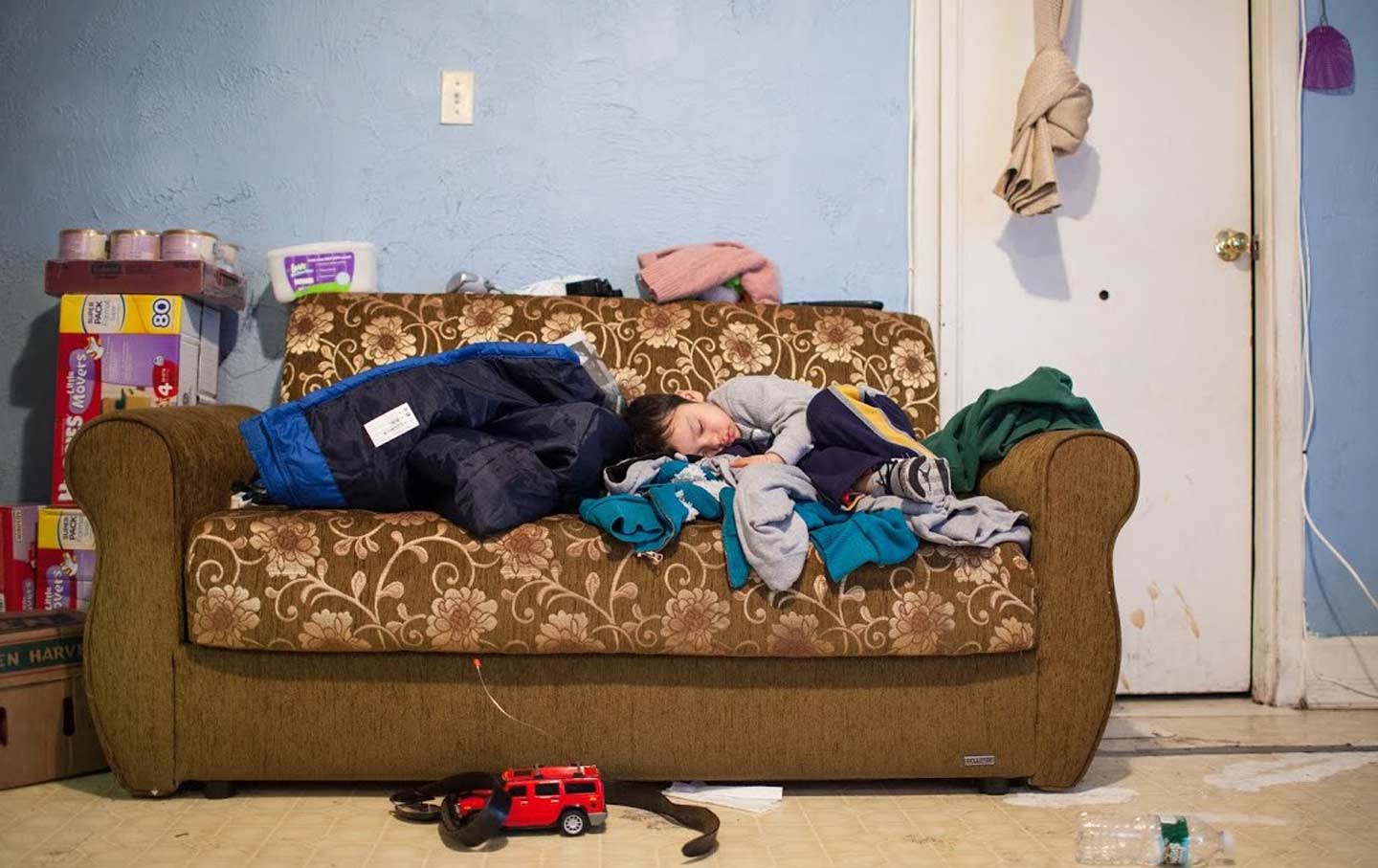 A photograph from the “Portraits of Hunger in NYC” exhibition features four-year-old Brandon, whose family makes a four-mile round trip to collect food at two Queens food pantries.