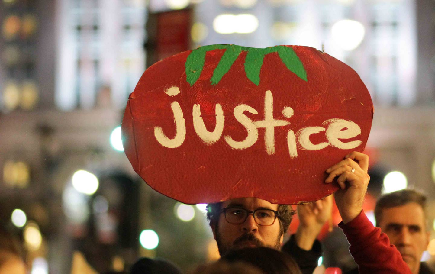 A marcher holds a sign at the Coalition of Immokalee Workers's rally for just working conditions in Florida tomato fields, November 16, 2015.