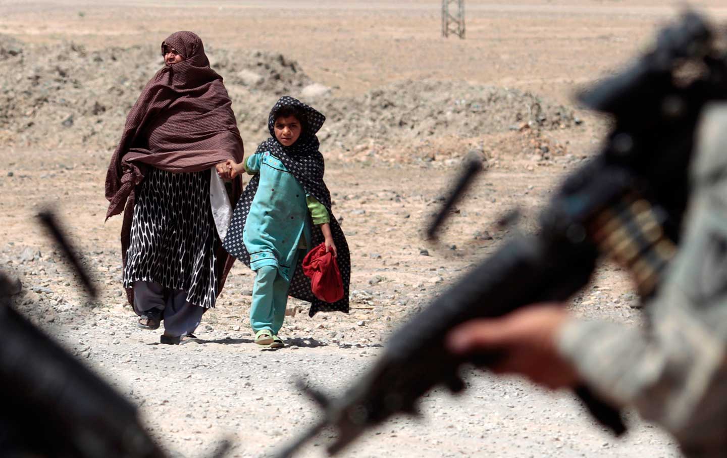 An Afghan woman and girl approach American troops in Kandahar.