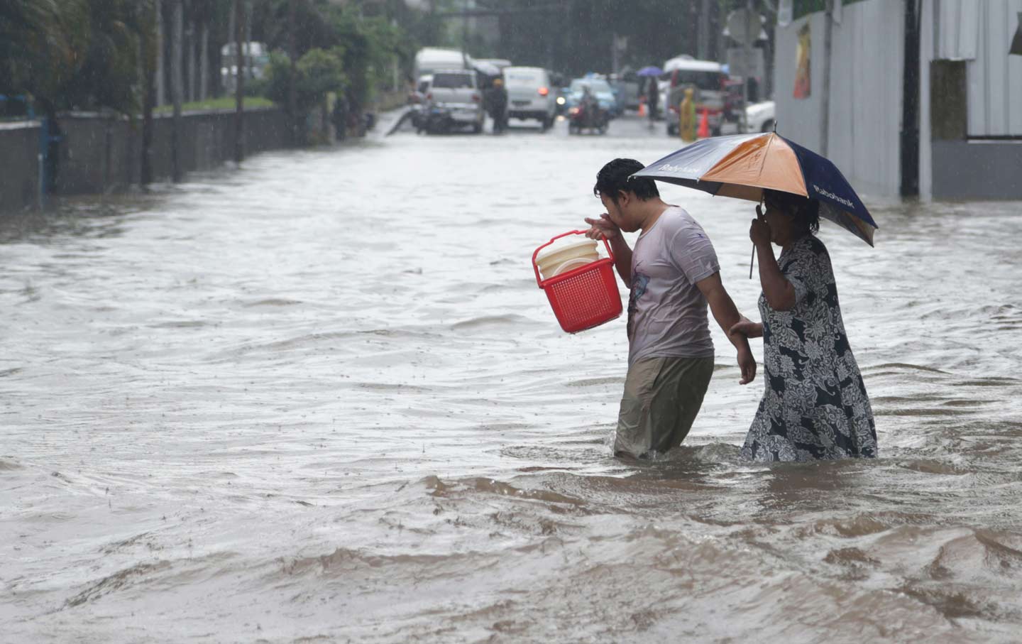 A couple wades through floodwaters in Jakarta, Indonesia.