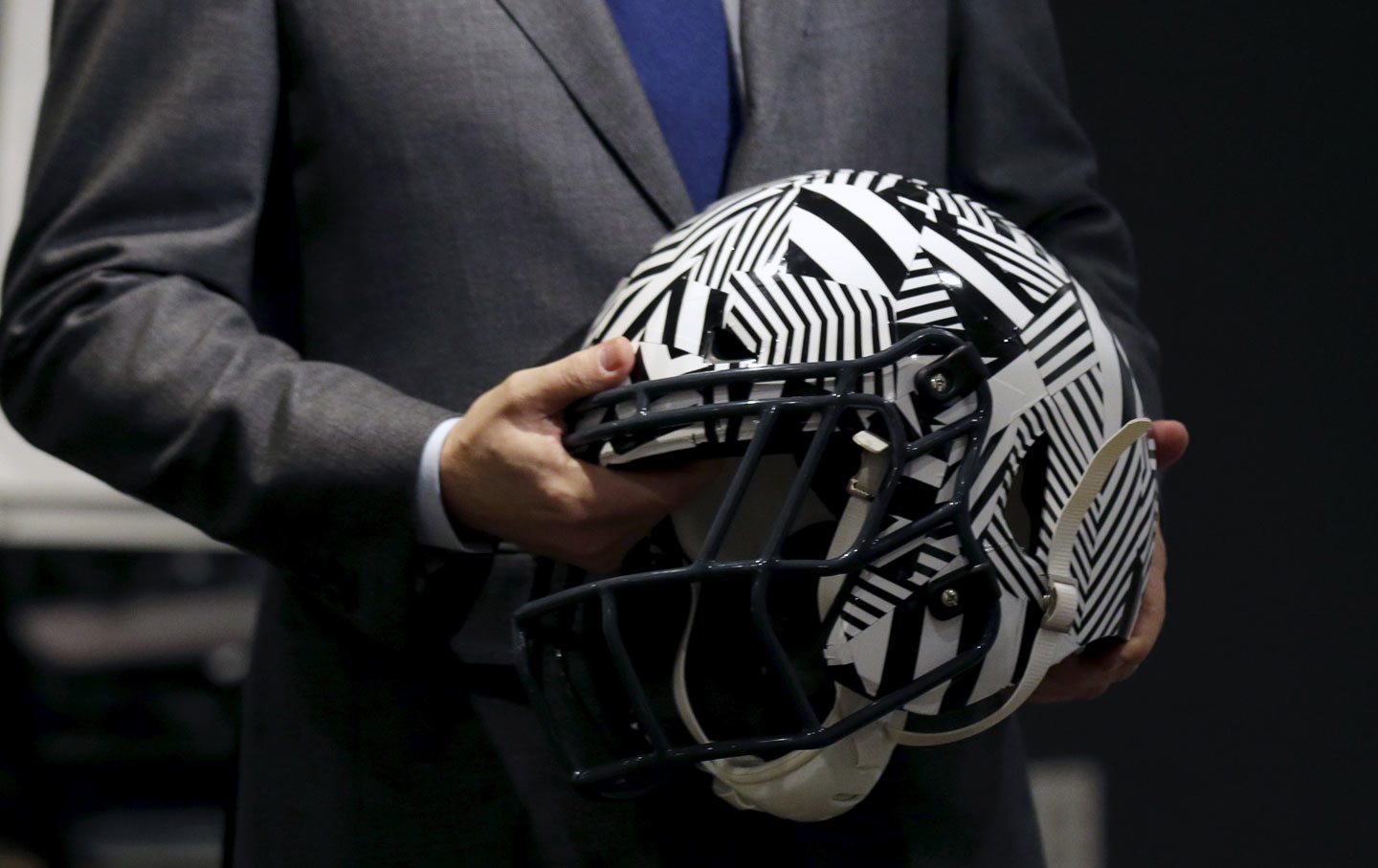 A representative holds an “impact-absorbing” helmet at NFL Headquarters in New York.