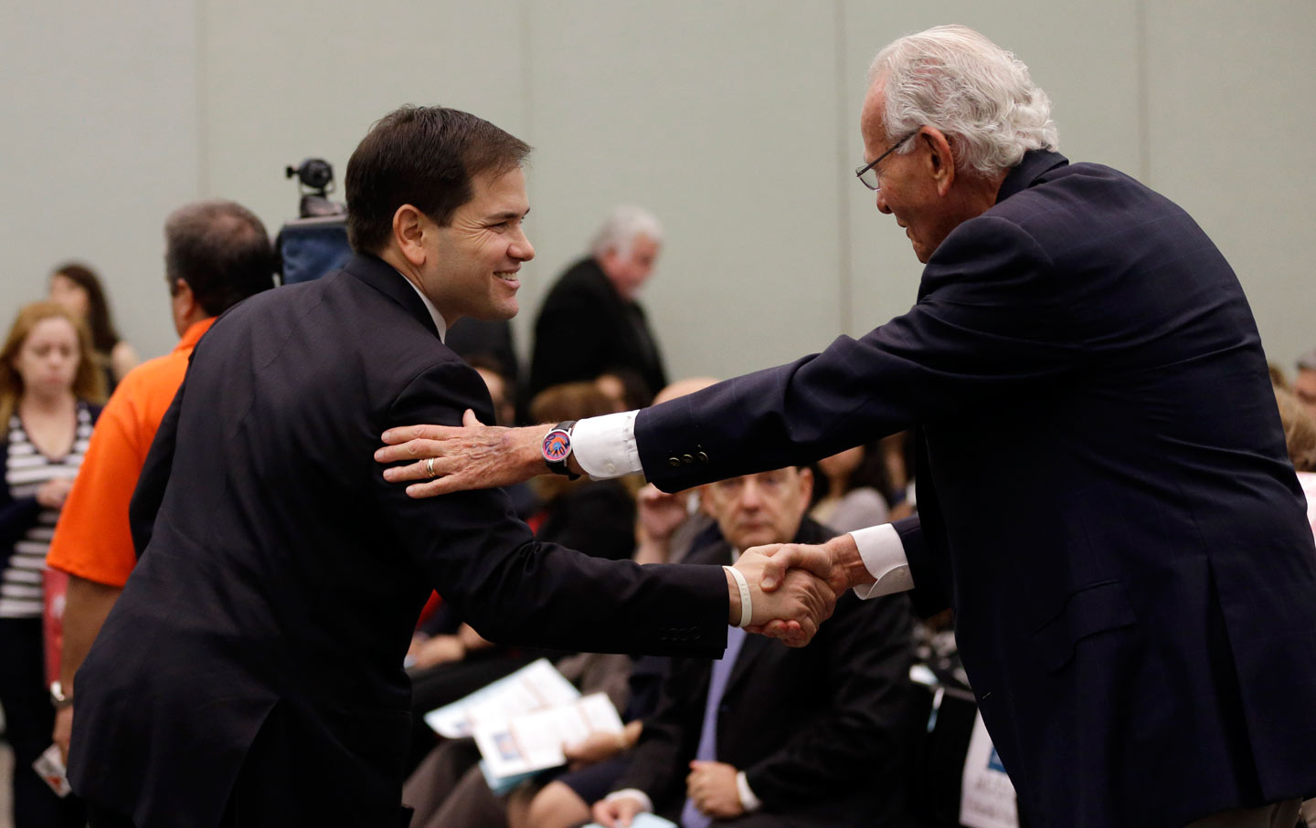 Marco Rubio shakes hands with major donor and former employer Norman Braman in Miami.