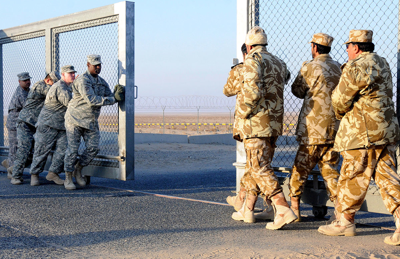 US and Kuwaiti soldiers close a gate between Iraq and Kuwait in December 2011.