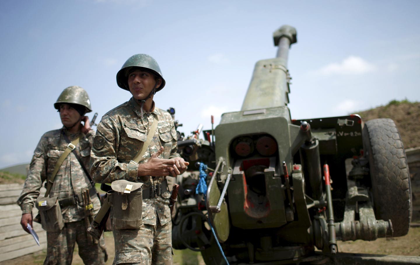 Ethnic Armenian soldiers stand next to a cannon