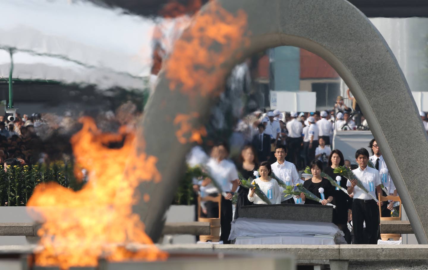 Relatives of the victims of the atomic bomb offer flowers at Hiroshima Memorial Cenotaph to mark the 70th anniversary of the US atomic bombing of Hiroshima on August 6, 2015.