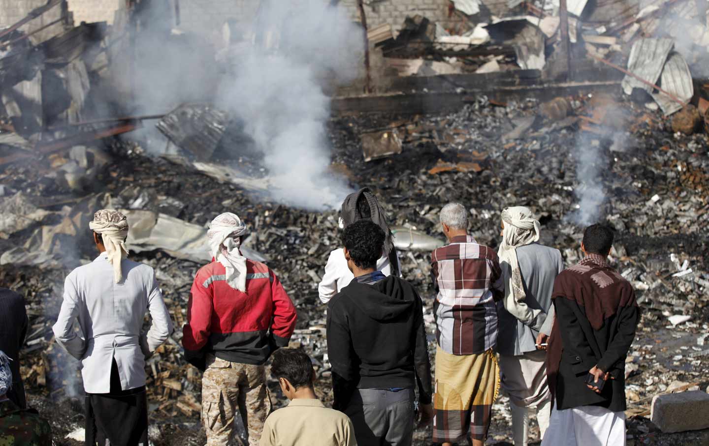 Civilans look at rubble from Saudi airstrike