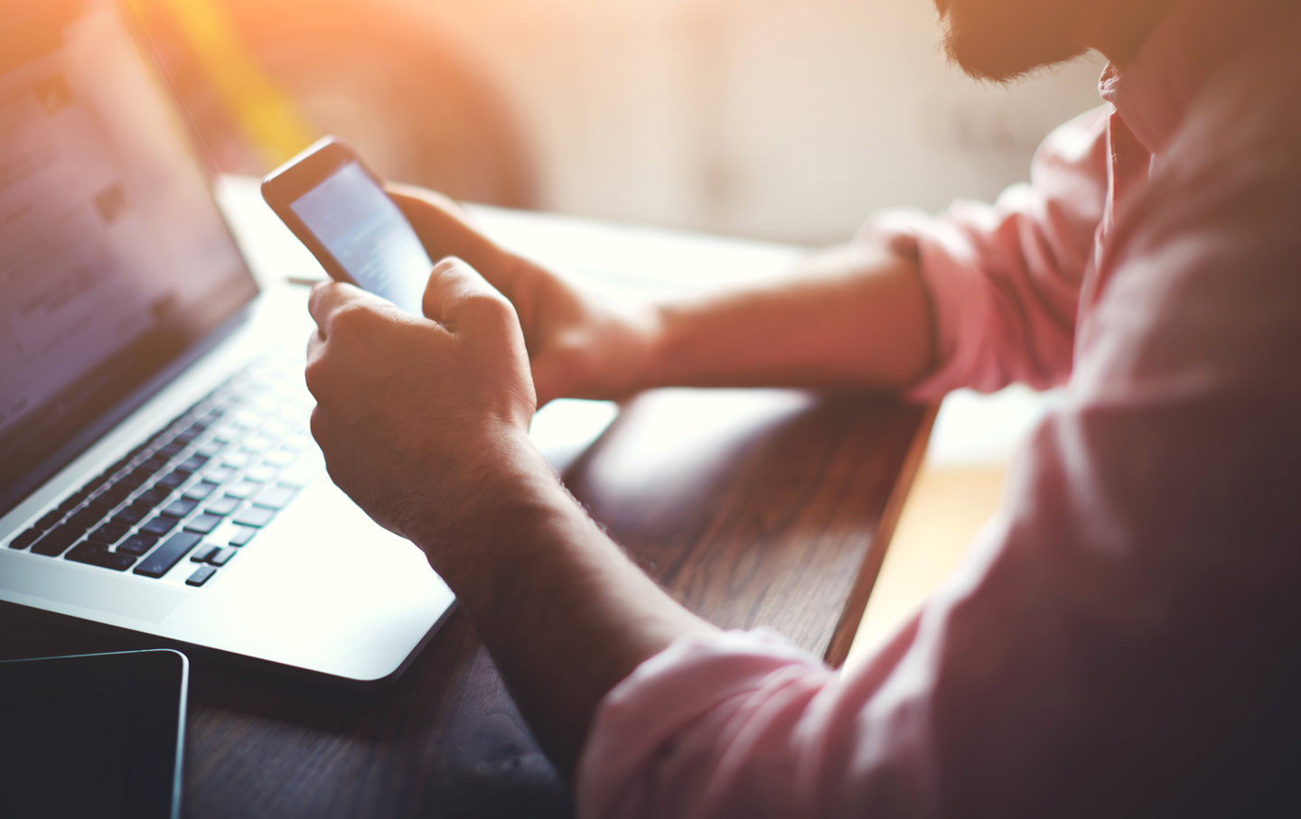 Person on phone in front of laptop