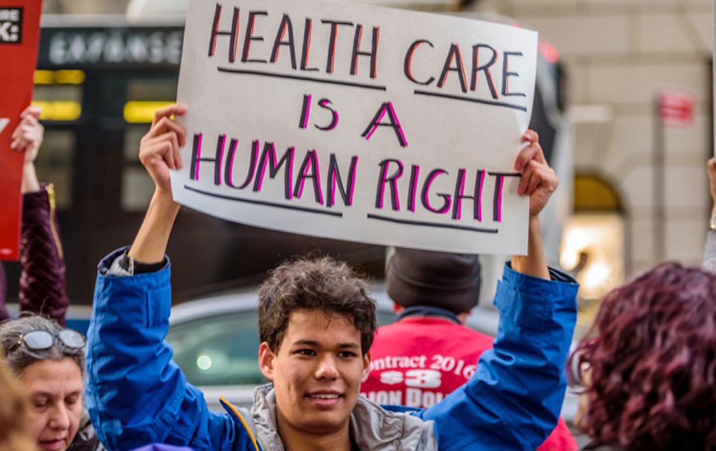 A young man holds up a sign at a recent rally against the repeal of the ACA