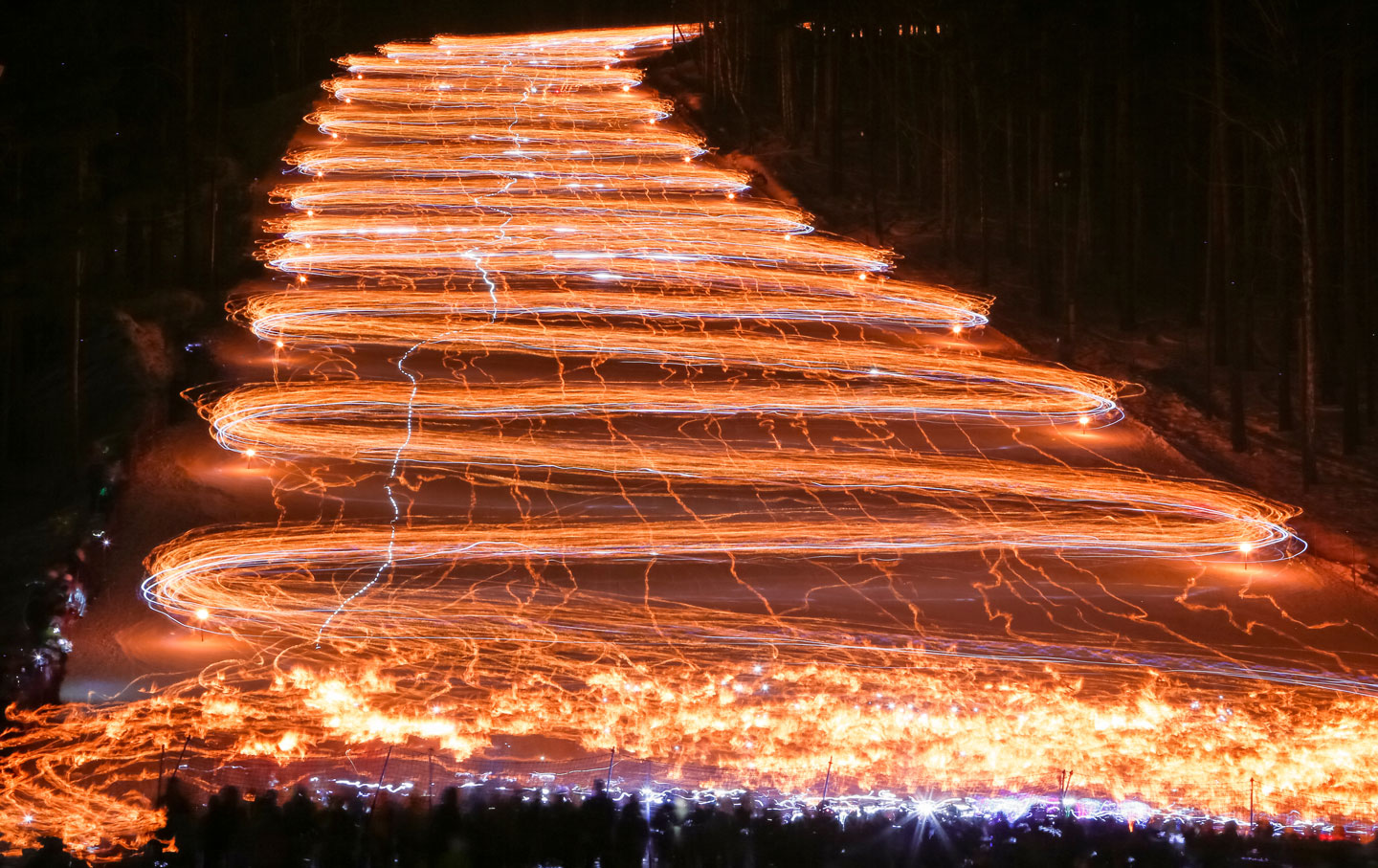 Hundreds of skiers and snowboarders descend from a slope