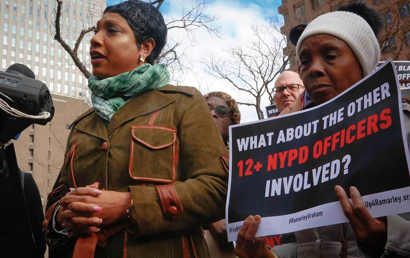 Constance Malcolm, mother of Ramarley Graham, speaks mother Patricia Hartley, right, holds a sign.