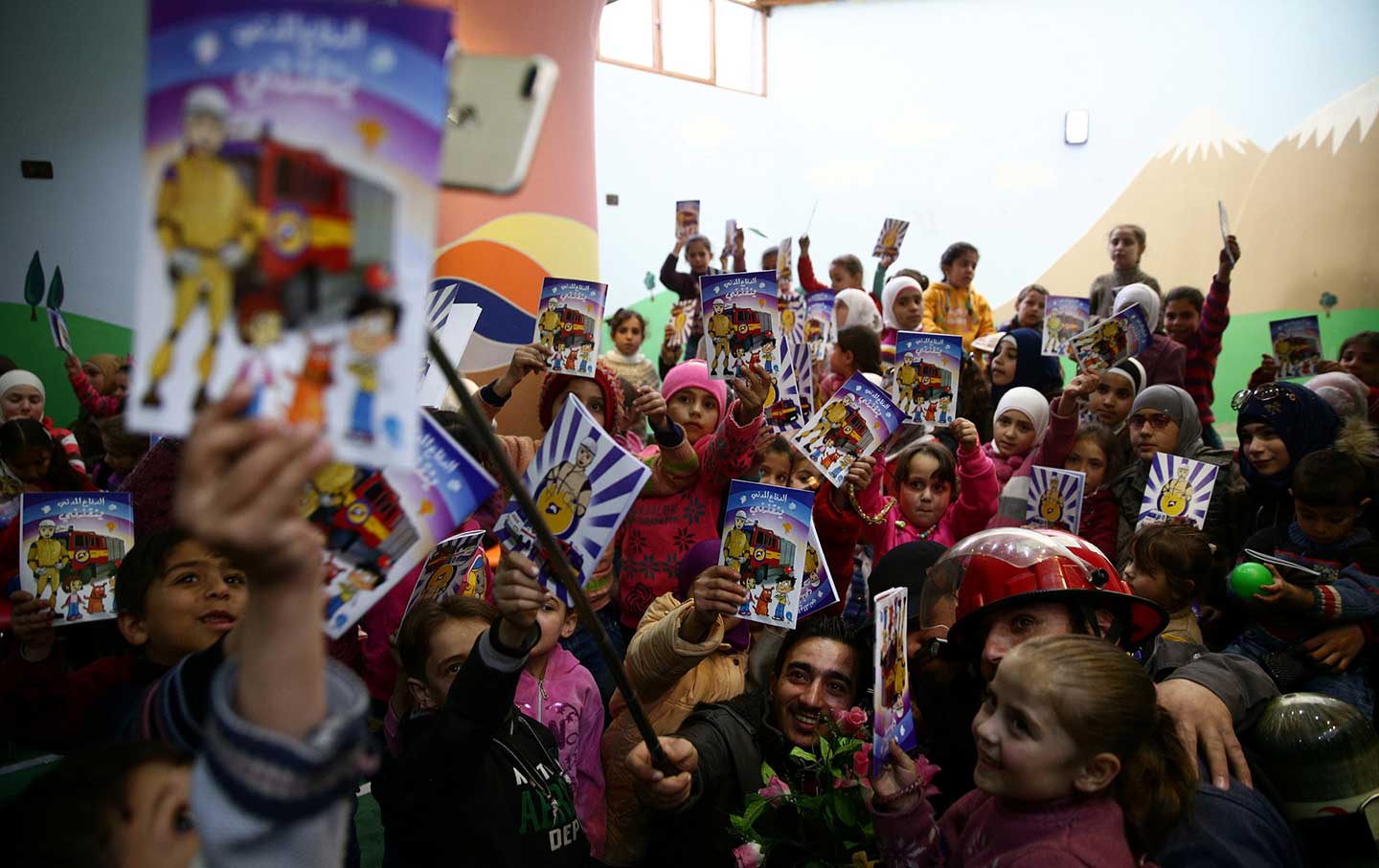 Syrian children display books from the White Helmets